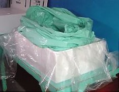 Multiple
        layers of heavy plastic bags, placed inside each other, are put inside plastic sheeting.
